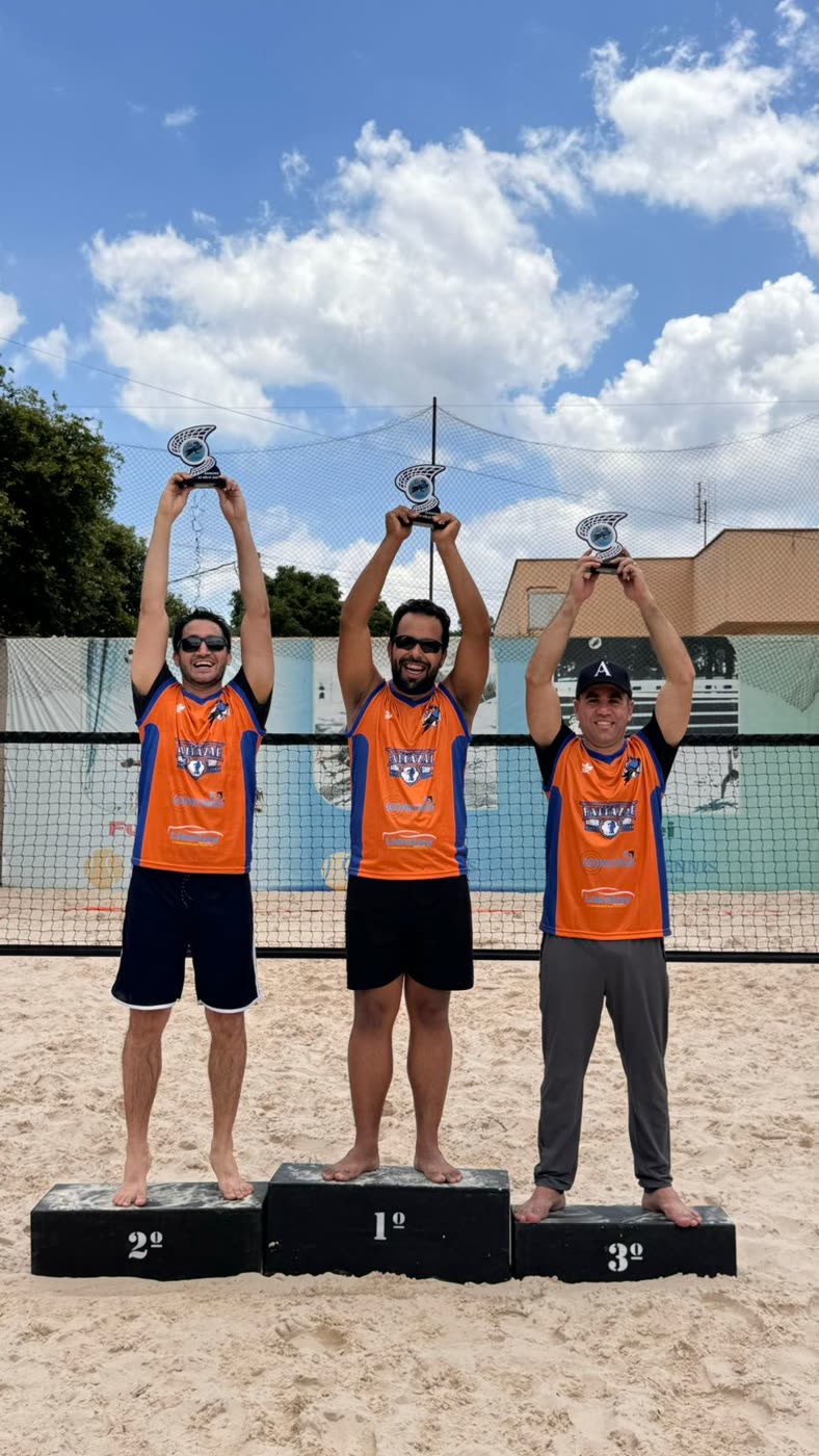 Três atletas no pódio da Ilha Tennis erguendo troféus, com camisas laranja e azul